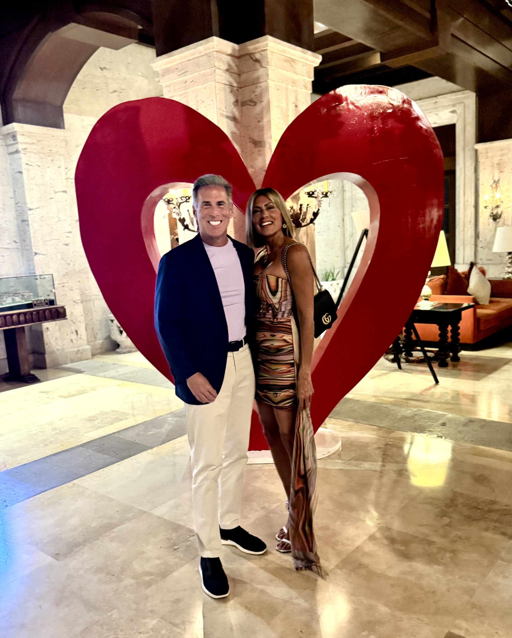 Johanna and Guy celebrating Valentine’s Day in Cabo in front of a red heart sculpture